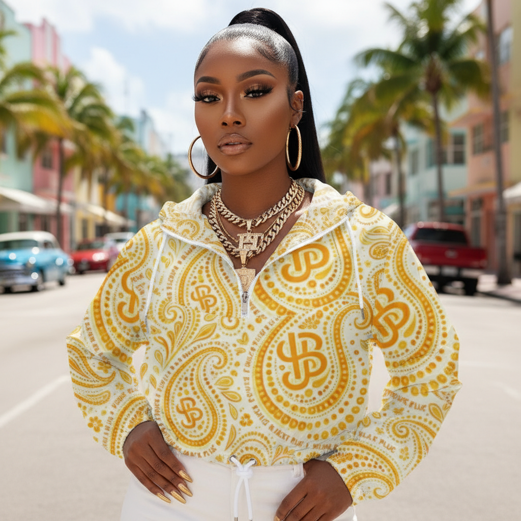 Woman wearing a yellow and white patterned hoodie on a city street with palm trees. YBP Cocktails Collection women's cropped windbreaker lightweight waterproof streetwear jacket